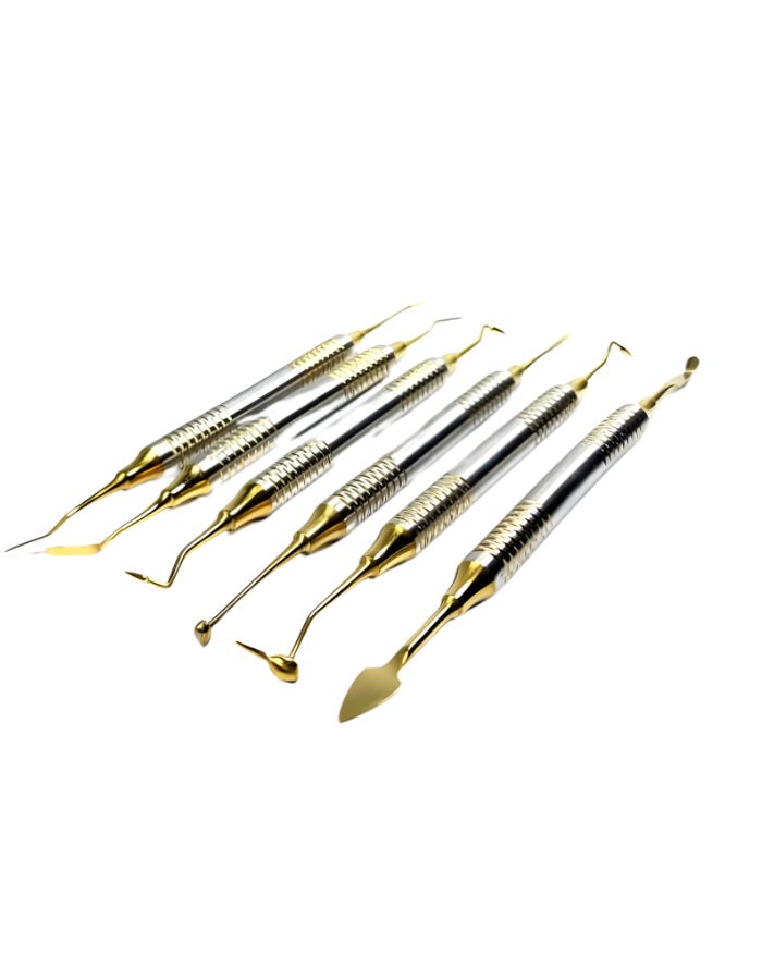 Set of dental tools with gold and silver handles on a white background