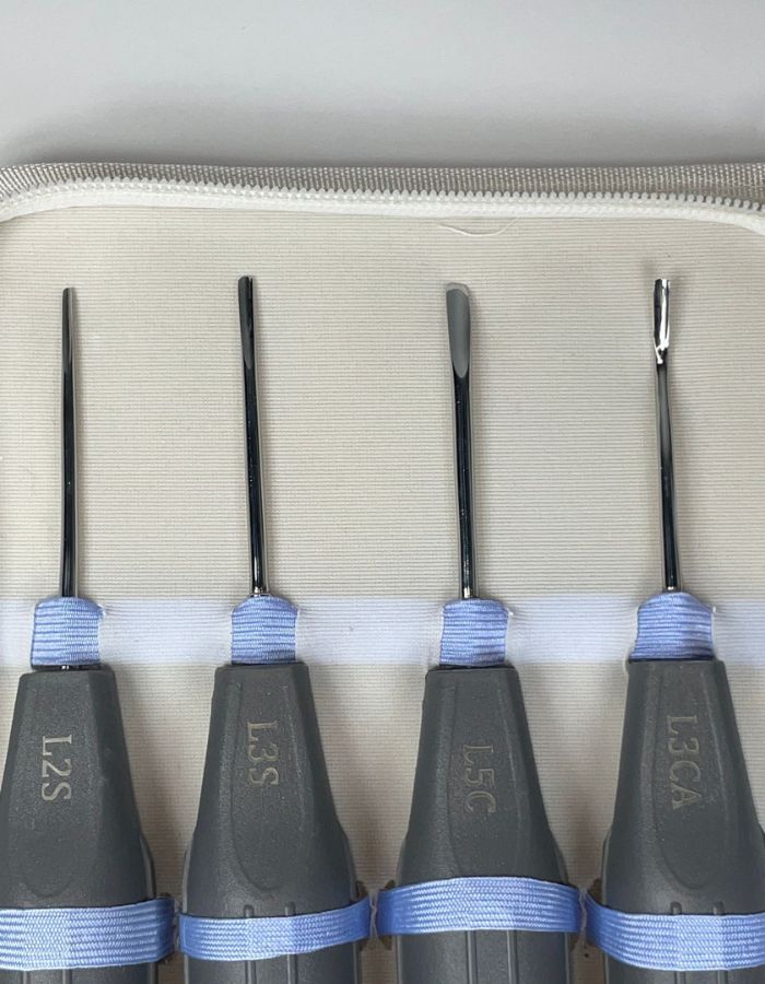 Set of four screwdrivers with different specifications on a beige background